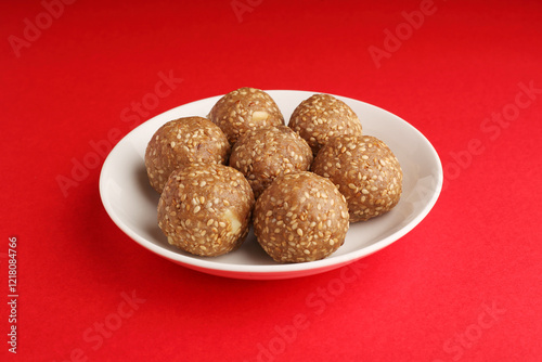 Sesame seed jaggery ball or til ke laddo and tilgul or til gul laddu served in bowl for Makar Sankranti Festival in India photo