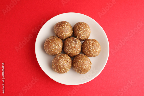 Sesame seed jaggery ball or til ke laddo and tilgul or til gul laddu served in bowl for Makar Sankranti Festival in India photo