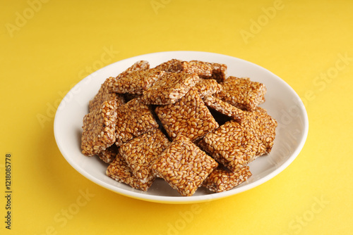 Sesame seed jaggery chikki or til ke chkki and tilgul or til gul ladduchikki served in bowl for Makar Sankranti Festival in India photo