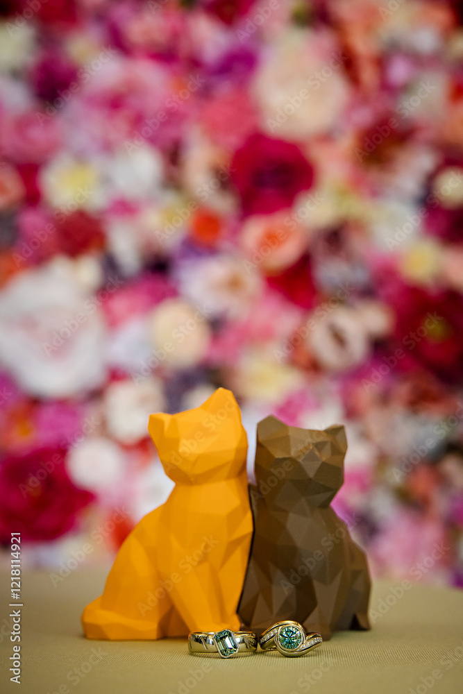Fototapeta premium Cute carved cat wedding toppers in front of a beautiful flower wall