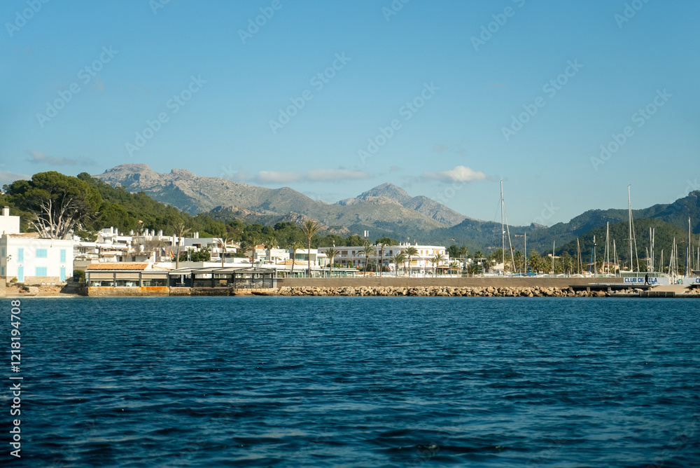 Naklejka premium A picturesque scene of boats lined up at Port d'Andratx, Mallorca, with stunning mountains in the background