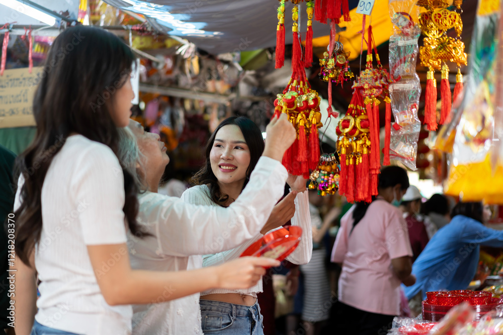 Mother and two daughter shopping for Chinese New Year decorations and ornaments Mother and two daughter shopping for Chinese New Year decorations and ornaments