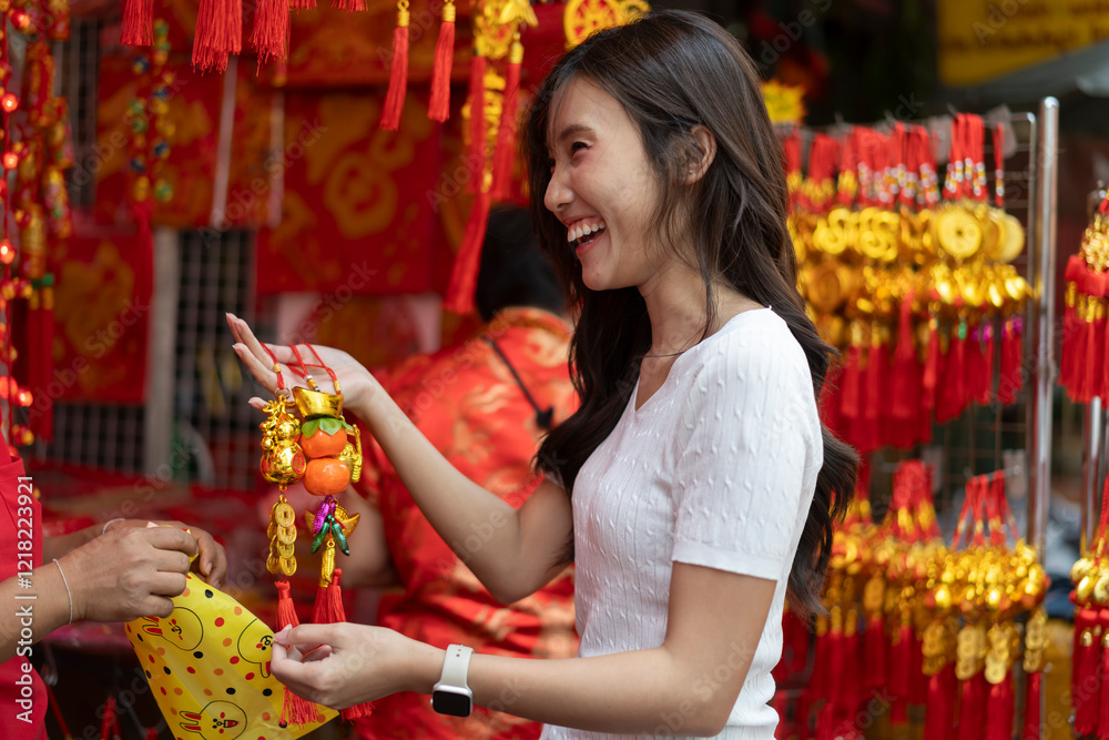 Obraz premium Young Asian Women Shopping for beautiful red ornament Offerings Outdoors market
