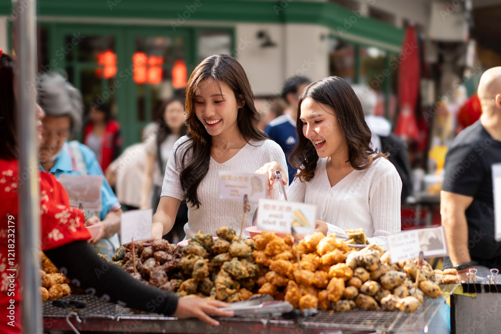 Two Women Enjoying Street Food at a Bustling Market in urban Two Women Enjoying Street Food at a Bustling Market in urban