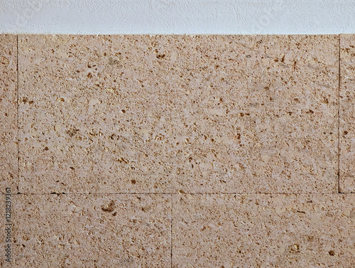 Smooth white wall texture background with yellow peach pink orange fossiliferous sandstone slabs cladding. Interior and exterior decoration with rustic mediterranean style textured stone rock tiles.