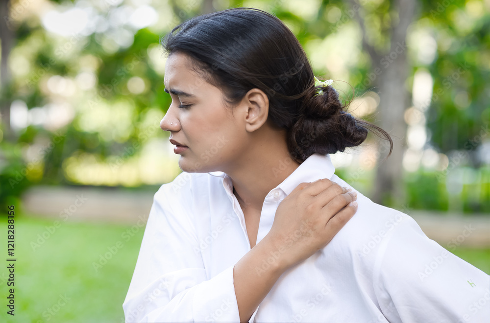 Unwell South Asian Indian young woman having shoulder sickness or neck pain from overwork or office syndrome, shoulder joint arthritis Unwell South Asian Indian young woman having shoulder sickness or neck pain from overwork or office syndrome, shoulder joint arthritis