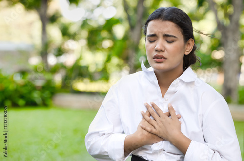 Unwell Indian woman suffering from heart condition, heart attack, irregular heartbeat