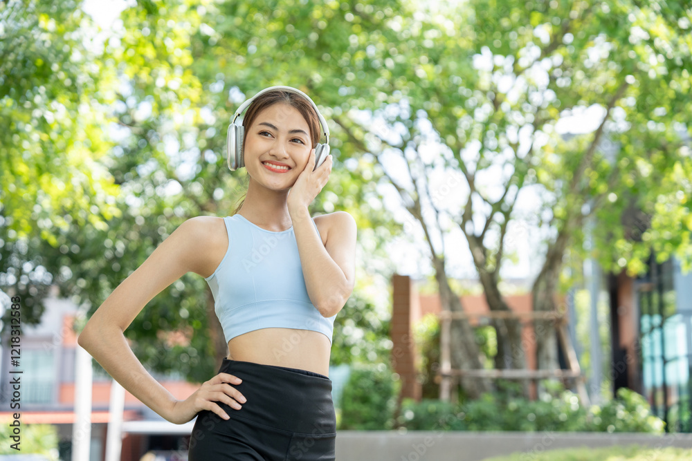 Happy slim beautiful woman wearing sportswear jogging in the park with sunrise. Young beautiful asian female in sportswear running outdoor. Workout exercise in the morning listen music with headphone Happy slim beautiful woman wearing sportswear jogging in the park with sunrise. Young beautiful asian female in sportswear running outdoor. Workout exercise in the morning listen music with headphone