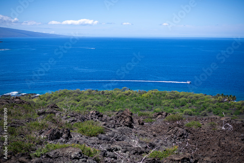 Boat speeds along lava Hawaiian coast at deep blue Kealakekua Bay photo