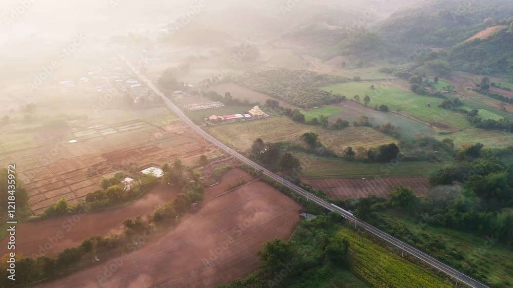 Aerial scenic drone fly road through rural rice fields landscape with burning smoke