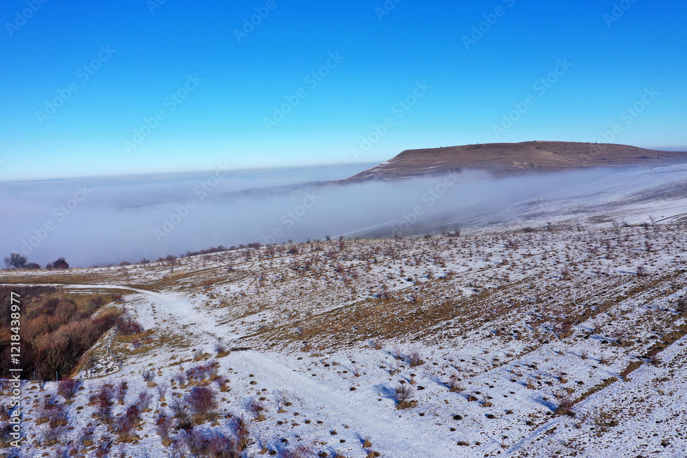 Aerial view of misty countryside hills at wintertime, morning fog above Aerial view of misty countryside hills at wintertime, morning fog above