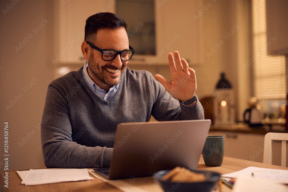 Happy man greeting someone while having online business meeting at home. Happy man greeting someone while having online business meeting at home.