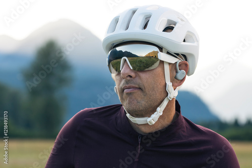 Male biker in golden light, wearing protective gear and headphones photo