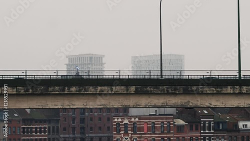 Busy city flyover captured with cars in motion against a backdrop of contrasting historical and modern architectures under a foggy sky, highlighting urban dynamics photo