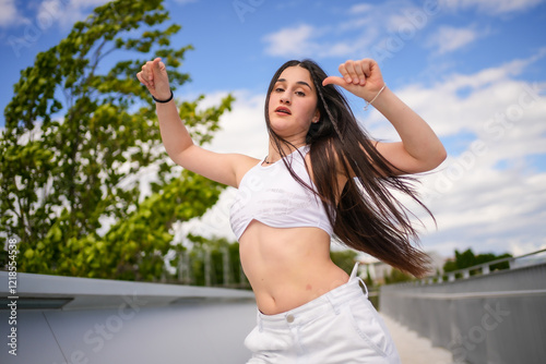 Woman with arms raised and tousled hair dancing freestyle photo