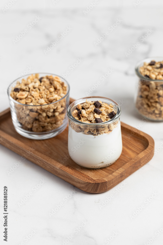 granola with chocolate, yogurt with granola in a glass jar granola with chocolate, yogurt with granola in a glass jar