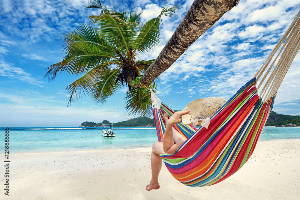Naklejka premium recreation on Seychelles island, relaxed woman in a colorful hammock on the beach