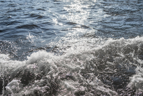 Water surface with ripples and sunlight reflections