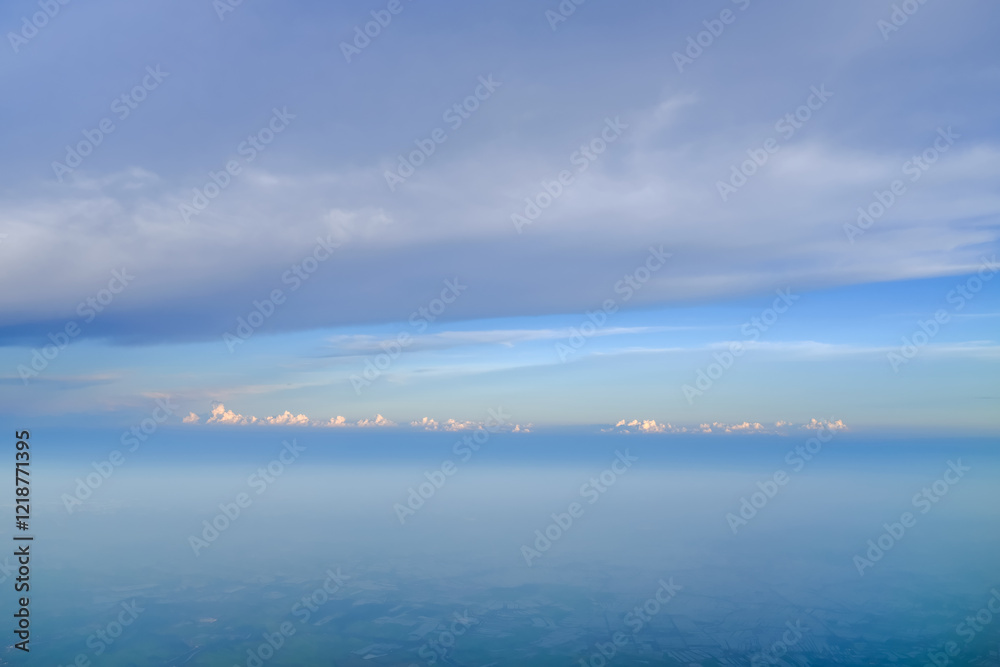 Looking through airplane window with dramatic cloudscape. white clouds with the blue sky from the high angle view. Cloudscape background. Nature scene. Looking through airplane window with dramatic cloudscape. white clouds with the blue sky from the high angle view. Cloudscape background. Nature scene.