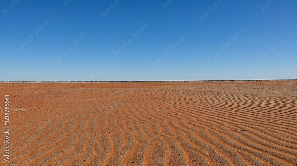 Naklejka premium A vast desert landscape with rippled sand under a clear blue sky, showcasing the beauty of arid environments.