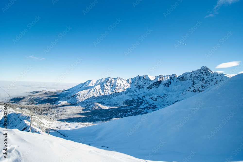 Obraz premium Tatra mountains at winter time. View of the white snow-capped peaks, frosty winter mountains. Kasprowy Wierch, High Tatra, Poland, Europe.