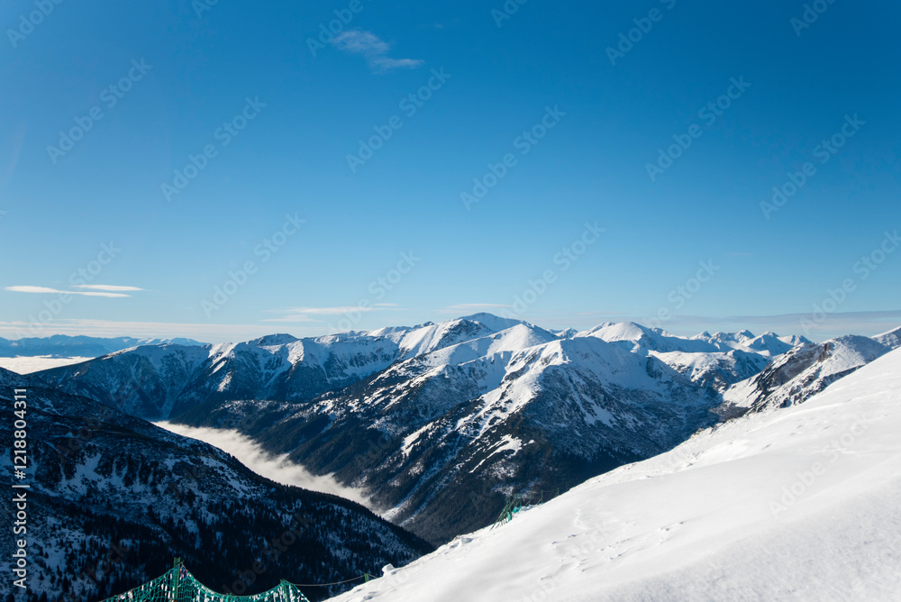 Fototapeta premium Tatra mountains at winter time. View of the white snow-capped peaks, frosty winter mountains. Kasprowy Wierch, High Tatra, Poland, Europe.