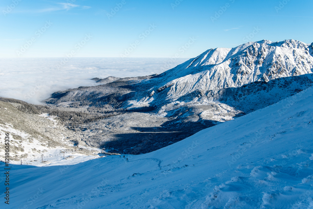 Obraz premium Tatra mountains at winter time. View of the white snow-capped peaks, frosty winter mountains. Kasprowy Wierch, High Tatra, Poland, Europe.