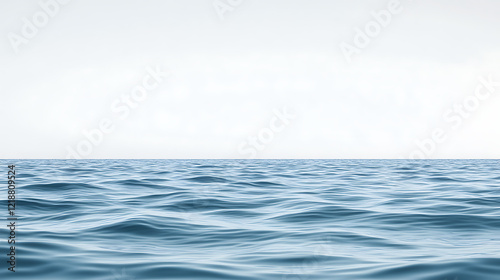 Serene ocean scene with large body of deep blue water. Small waves gently ripple surface. Light gray sky provides contrast to dark blue water. Low angle view looks up at vast ocean expanse. Isolated. photo