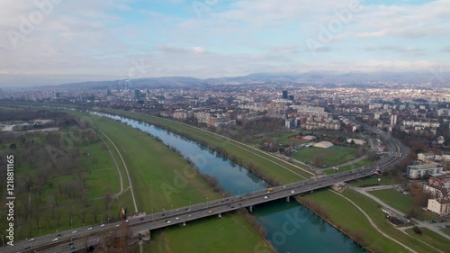 Panorama of the river Sava flowing through Zagreb the capital city of Croatia and a view of the famous Bridge of Youth (Most Mladosti). Backward aerial shot. photo