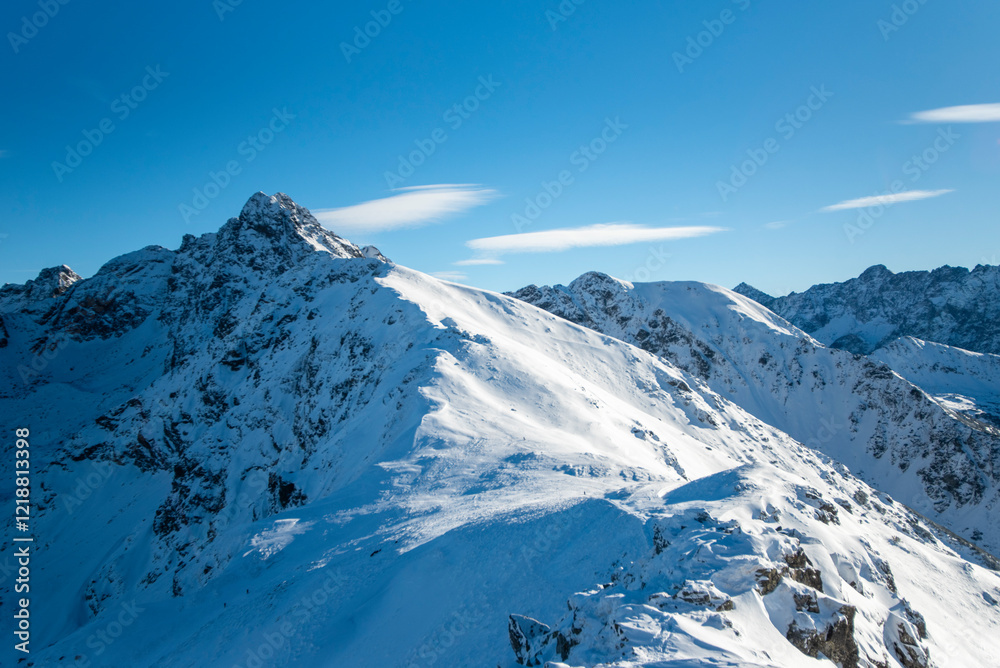 Obraz premium Tatra mountains at winter time. View of the white snow-capped peaks, frosty winter mountains. Kasprowy Wierch, High Tatra, Poland, Europe.