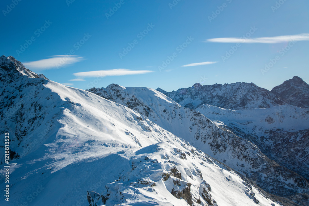 Obraz premium Tatra mountains at winter time. View of the white snow-capped peaks, frosty winter mountains. Kasprowy Wierch, High Tatra, Poland, Europe.
