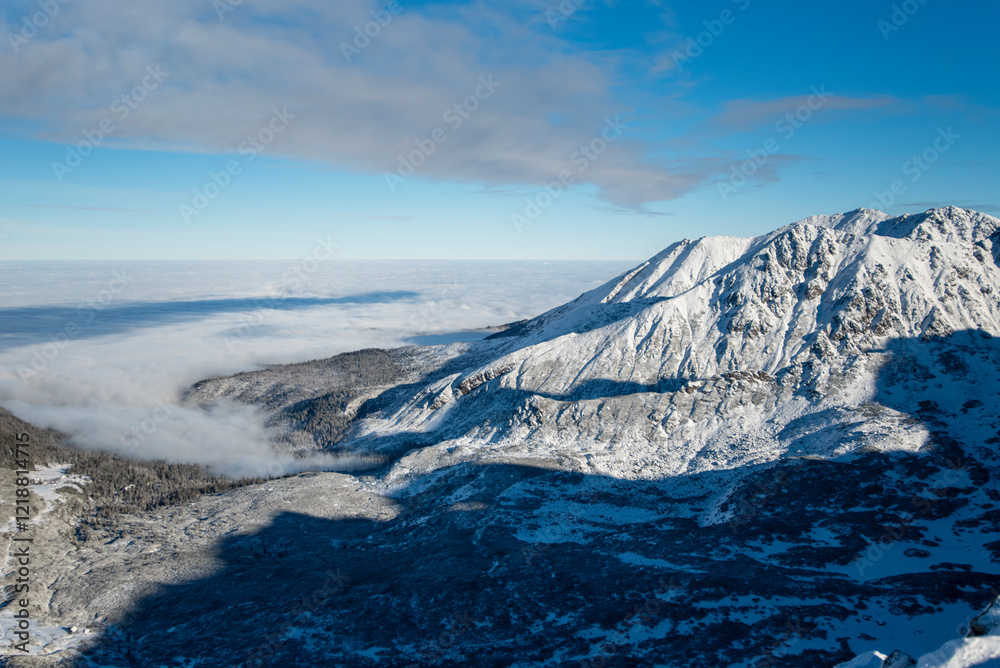 Obraz premium Tatra mountains at winter time. View of the white snow-capped peaks, frosty winter mountains. Kasprowy Wierch, High Tatra, Poland, Europe.