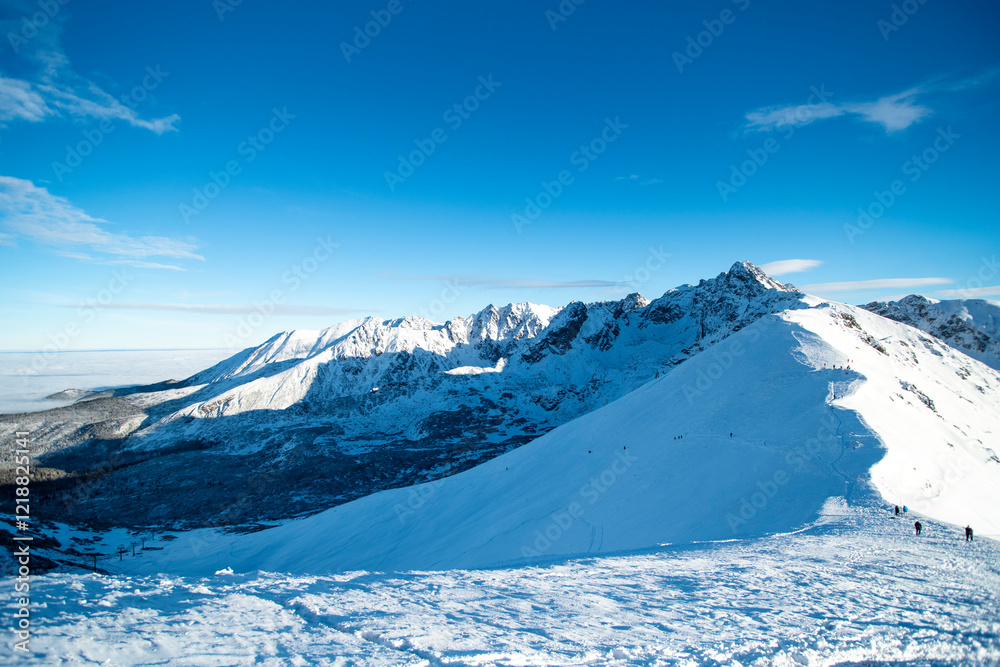 Obraz premium Tatra mountains at winter time. View of the white snow-capped peaks, frosty winter mountains. Kasprowy Wierch, High Tatra, Poland, Europe.