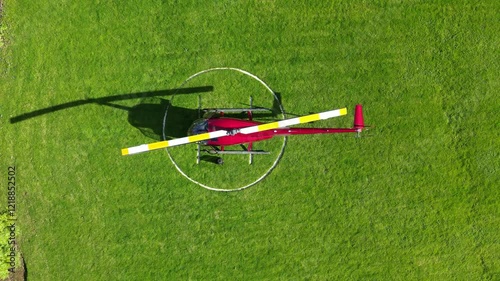 helicopter parked green grass field helipad shadow against vibrant landscape aviation top down birdseye aerial shot view upwards heliport london scenic travel  photo