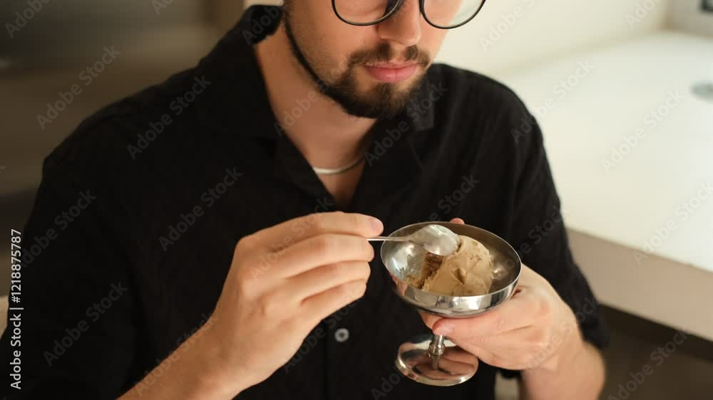 portrait of a young man with a beard eating ice cream in a stylish cafe