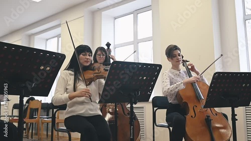 String quintet rehearsing in cozy studio showcasing harmony of classical instruments Quintets unity and talent create a mesmerizing blend of sound ideal for cultural or artistic projects