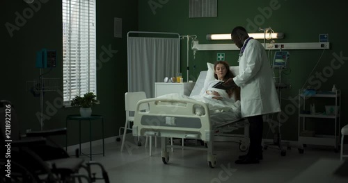 Patient looks at her X-ray as the doctor points out details on the table.
