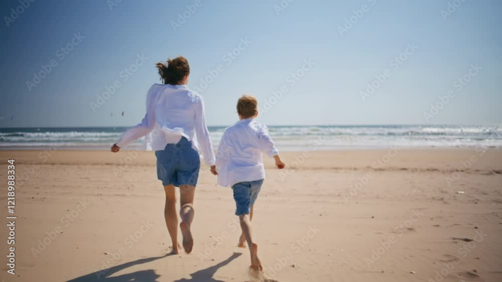 Running mom holding hand beloved son spending summer activity on sunny beach. Running mom holding hand beloved son spending summer activity on sunny beach.