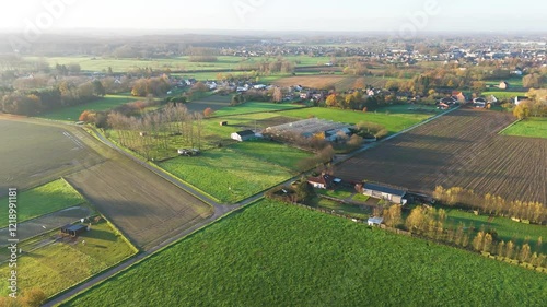 vast agriculture fields belgian countryside during early morning sunshine golden light enhances farmland aerial drone panning shot beauty richness visual delight experience community 