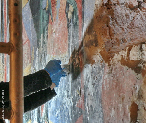 Restorer paintings on frescoes of religious motifs in Orthodox Christian monasteries	 photo