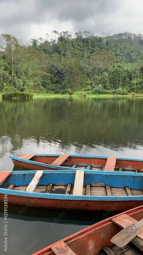 View of Kumpe Lake in Banyumas, Central Java, Indonesia, captured on January 25, 2025. A traditional wooden boat floats on calm waters, surrounded by lush greenery, showcasing Indonesia's serene lands View of Kumpe Lake in Banyumas, Central Java, Indonesia, captured on January 25, 2025. A traditional wooden boat floats on calm waters, surrounded by lush greenery, showcasing Indonesia's serene lands