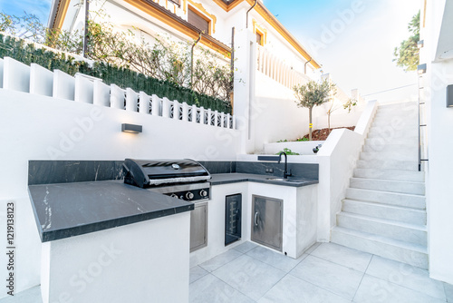 a private outdoor kitchen barbecue area in the garden of luxury mediterranean real estate 