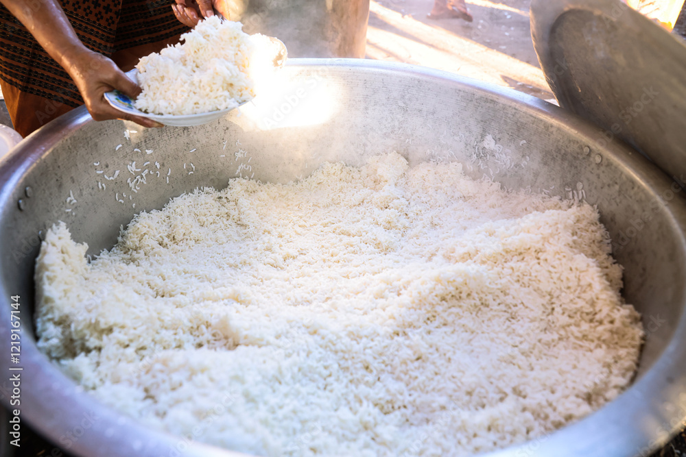 Scooping rice from a large pot at festivals, parties, or places where large quantities of food are cooked, in Myanmar. Scooping rice from a large pot at festivals, parties, or places where large quantities of food are cooked, in Myanmar.