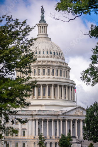 US Capitol Building in Washington, DC - Partial View on a sunny Summer Day with blue Sky; Trees in Foreground