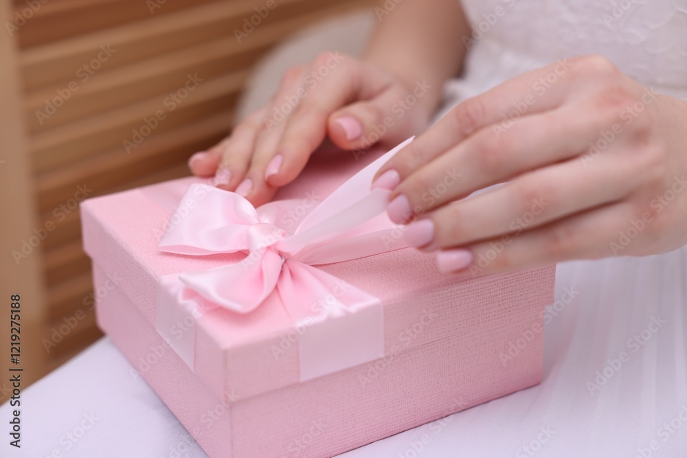 Bride opening beautiful wedding gift indoors, closeup Bride opening beautiful wedding gift indoors, closeup
