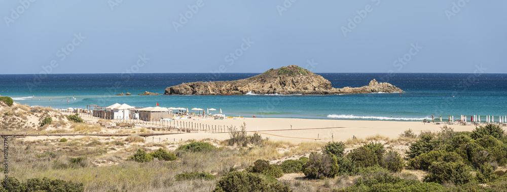 The beautiful beach of Su Giudeu in the south of Sardinia with transparent and turquoise water and a small island in front of the bay