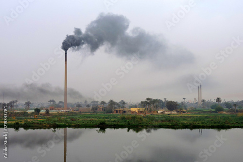 The chimney of an old factory on the bank of the Nile, Egypt. It's probably a brick factory photo