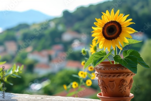 A vibrant sunflower in a terracotta pot against a peaceful landscape backdrop. photo