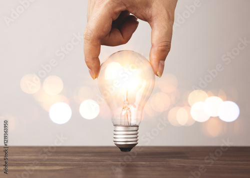 Hand holding a light bulb with bright light. Concepts of creative innovation, new ideas, knowledge management and inspiration.