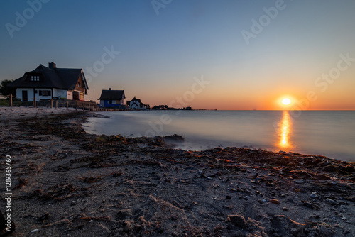 Blick von den Strandhäusern in Heiligenhafen auf die Ostsee im Sonnenuntergang photo